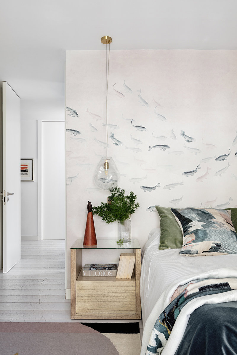 Dormitorio con papel pintado con estampado de peces.
