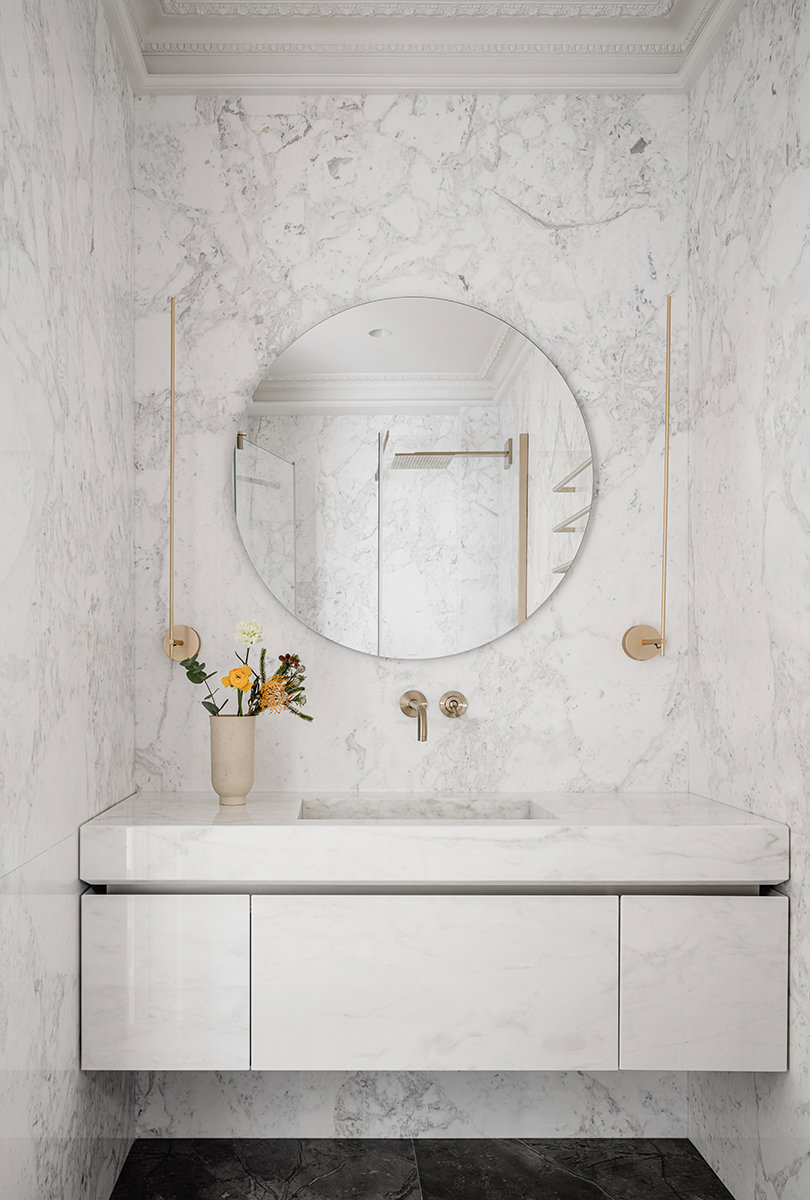 Baño moderno con paredes y mueble con acabado mármol