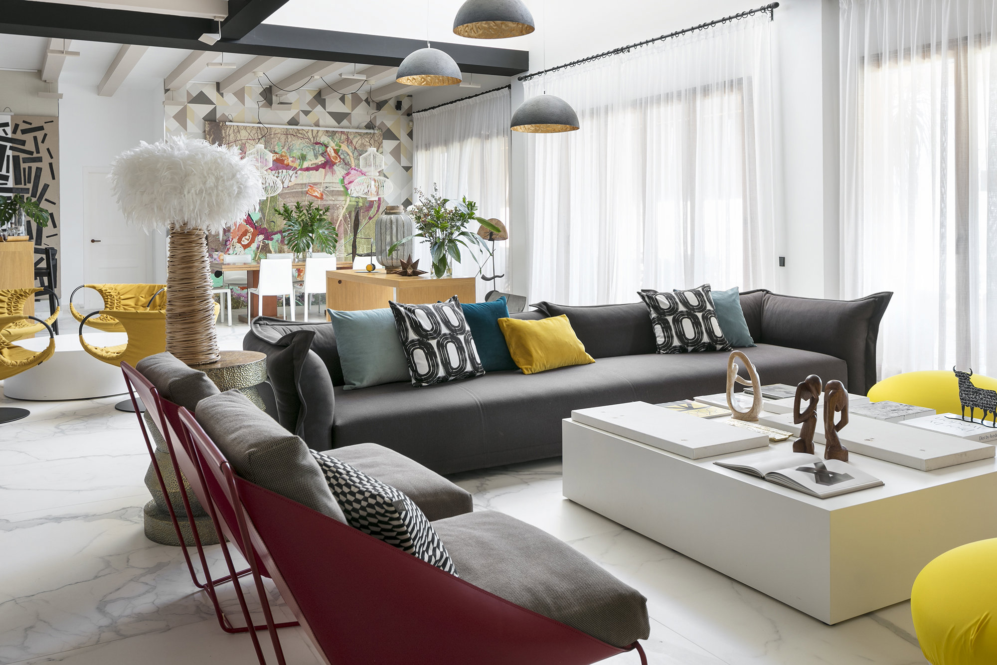 Salón comedor con sofá gris y muebles de diseño.  