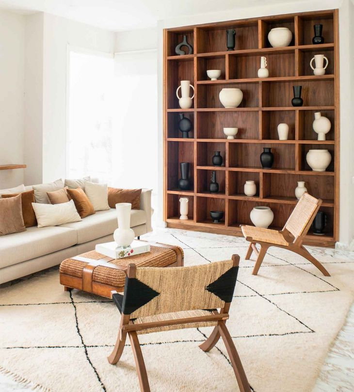 muebles de madera y cojines marrones en un salon blanco
