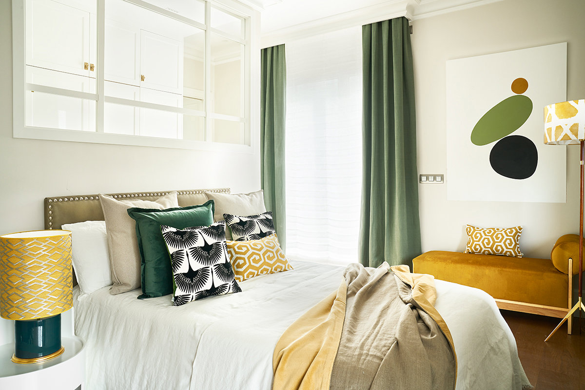 Dormitorio matrimonio con detalles en verde y mostaza.