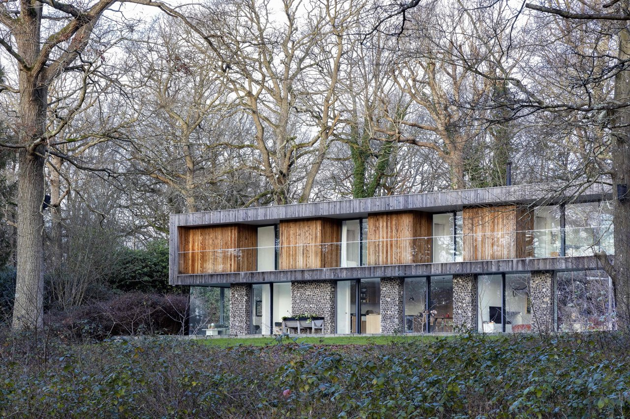 Casa moderna construida en madera y piedra en medio de un bosque
