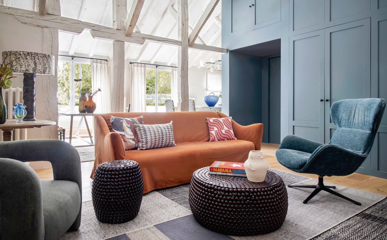 Salón rústico paredes azules y sofá naranja
