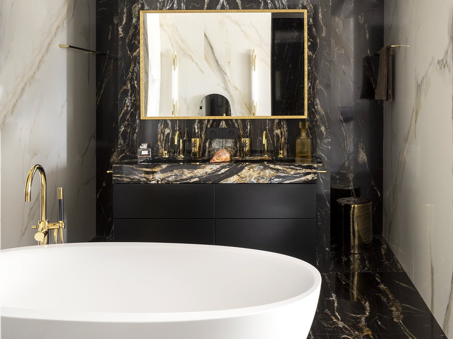 Baño sofisticado con bañera en negro y dorado
