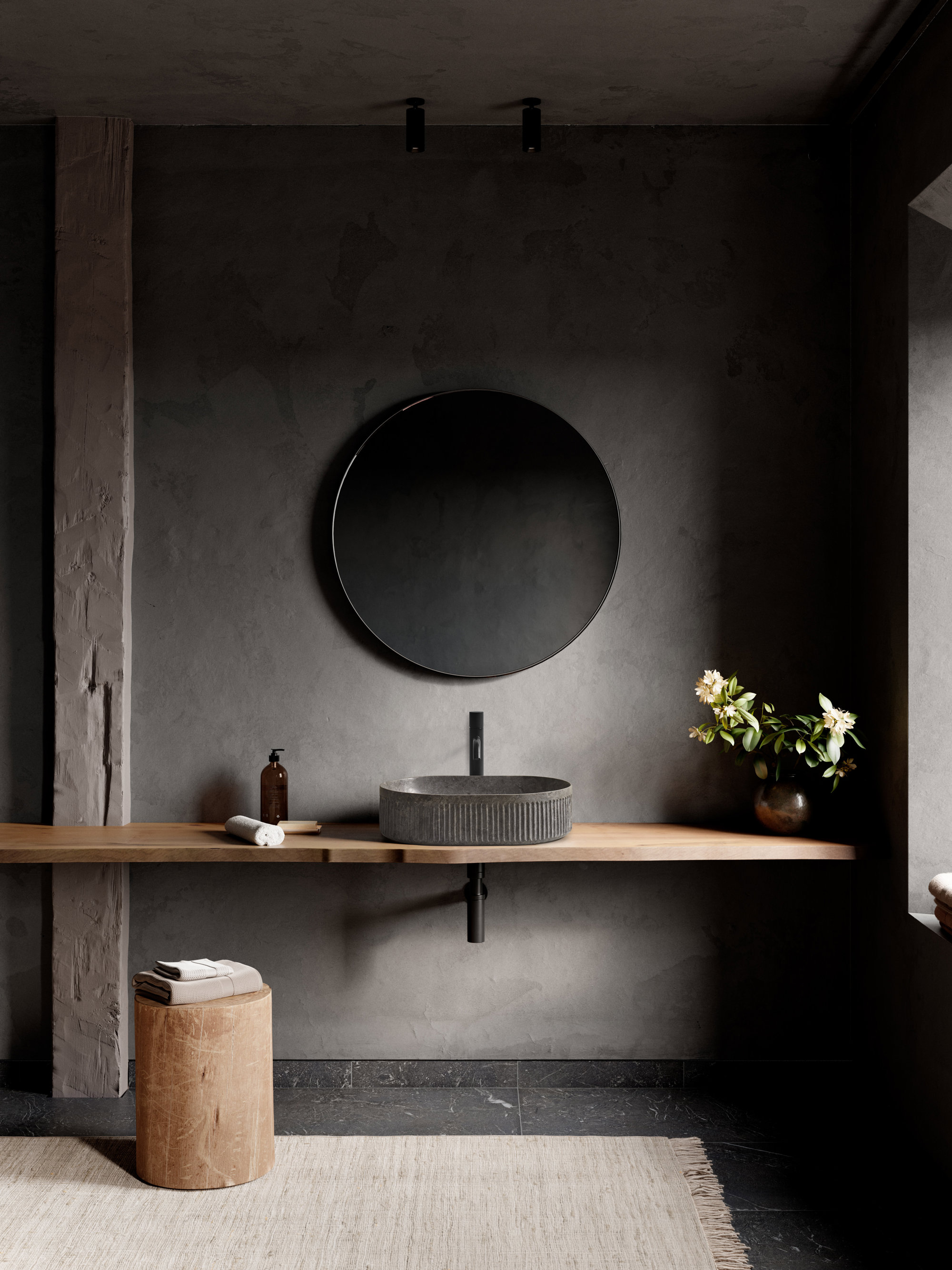 Un baño moderno en tonos oscuros con encimera de madera. 