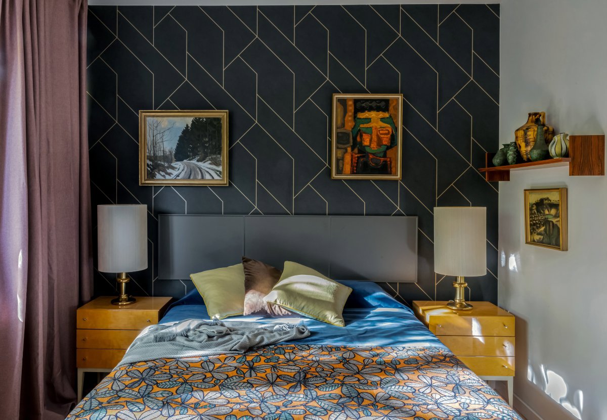 Dormitorio colorido con papel pintado azul y líneas geométricas doradas