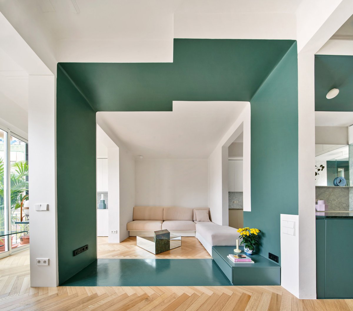 Salón verde y pequeño habilitado en una zona de paso gracias a un cubículo verde