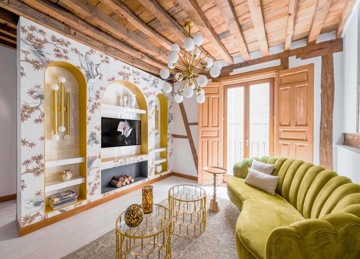 Salón pequeño con techo de madera, sofá pistacho y elementos en dorado