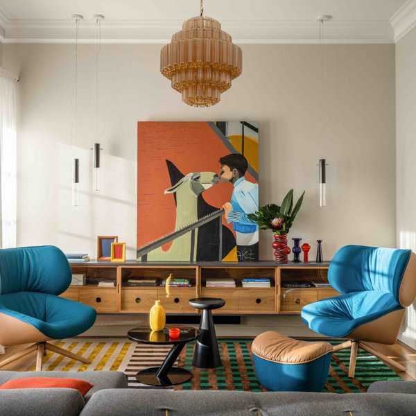En este salón, el mueble bajo de madera cobra vida gracias al cuadro, las butacas azules y los accesorios de colores