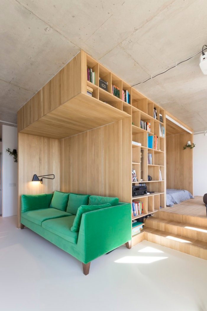 Salón pequeño dentro de una estructura de madera y sofá verde