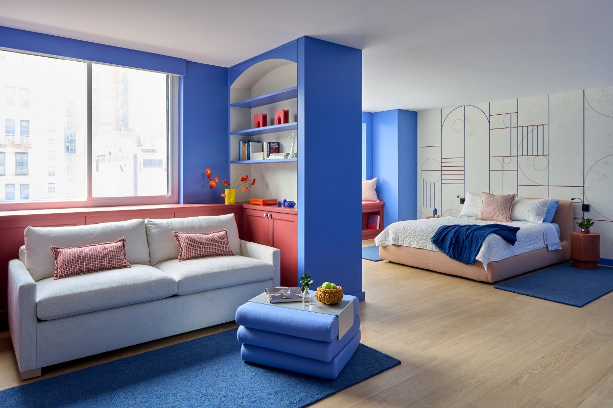 Salón pequeño todo en azul, con sofá y mueble en rojo