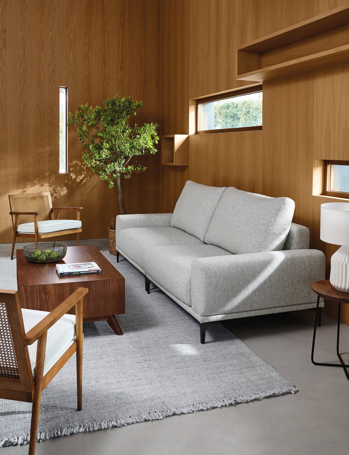 Salón pequeño panelado en madera con sofá gris