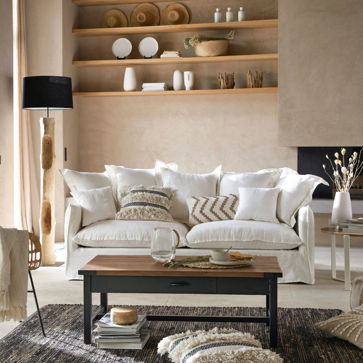 Salón en tonos tierra con sofá en blanco y baldas de madera
