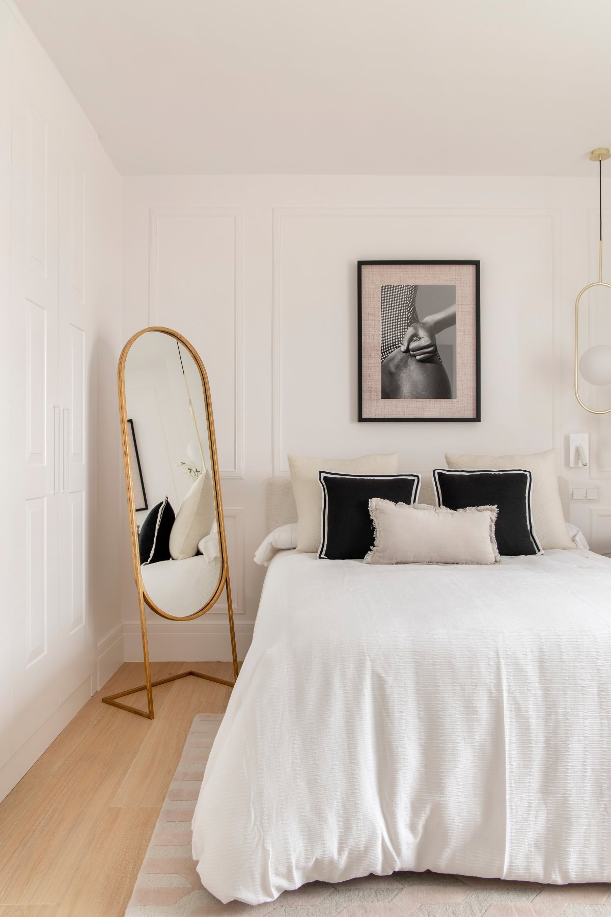 Dormitorio con molduras y detalles en negro en textil y cuadro