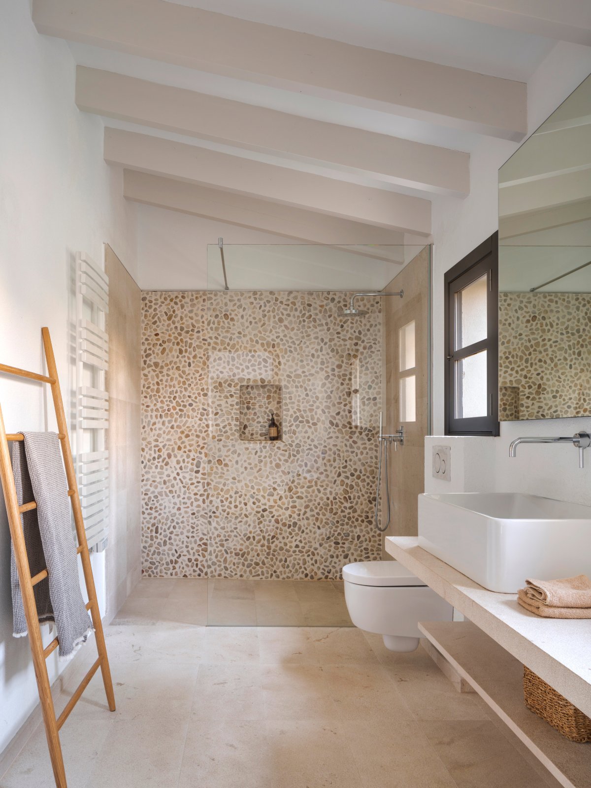Baño con ventana con pared de la ducha en piedra