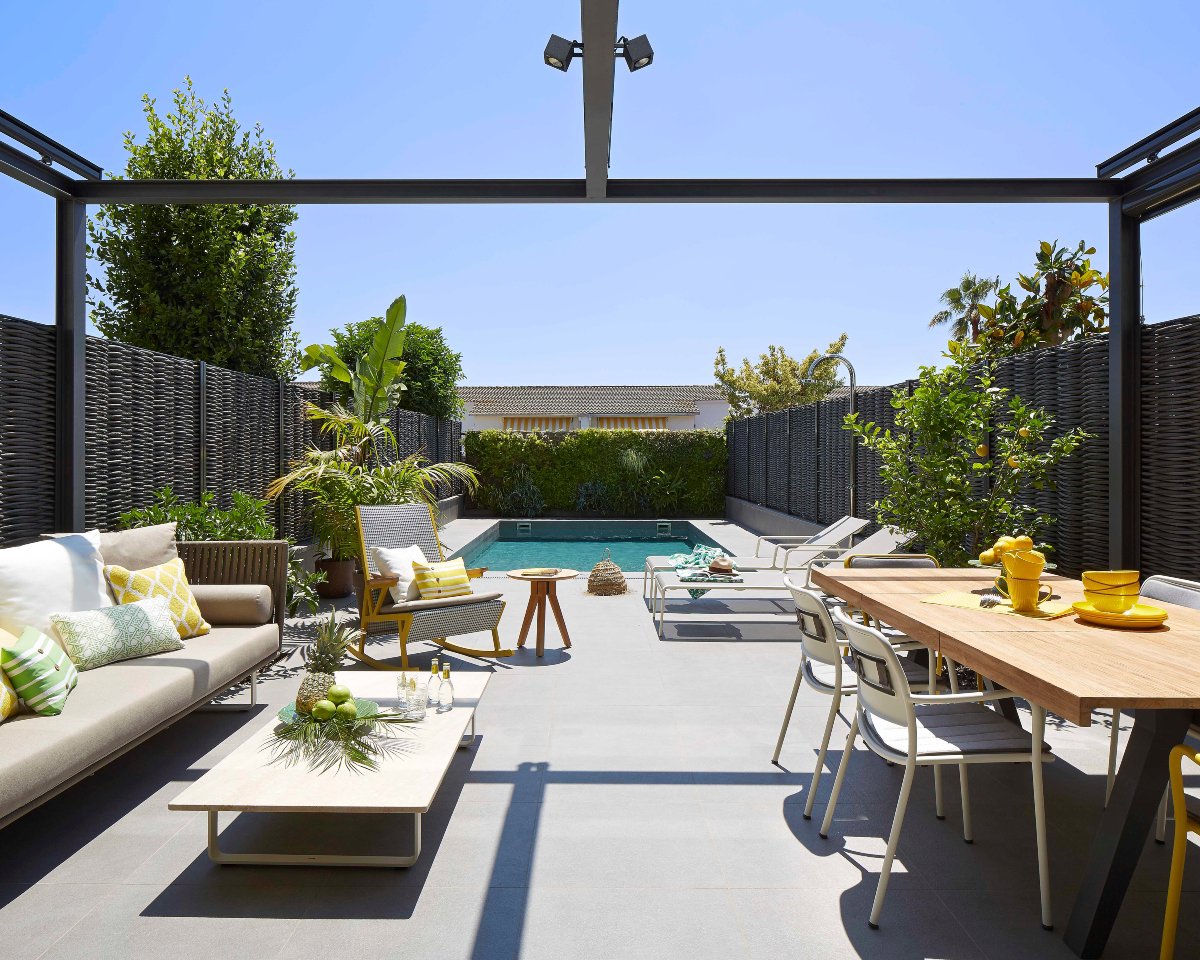 Terraza con piscina, mesa de comedor y sofá en tonos claros