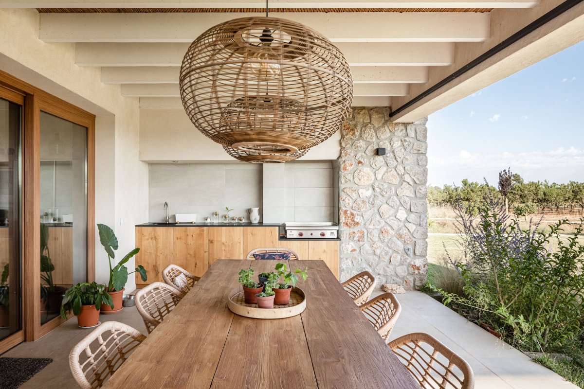 Terraza con cocina exterior y mesa alargada