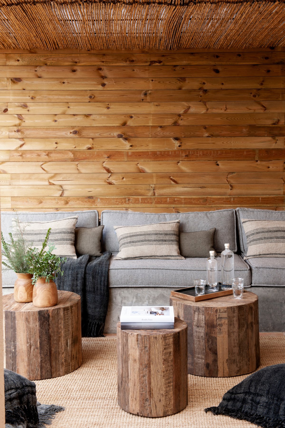 Terraza de madera en pared y techo con banco de obra en gris