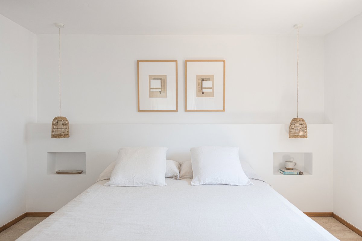 Dormitorio blanco con cabecero y mesillas de obra