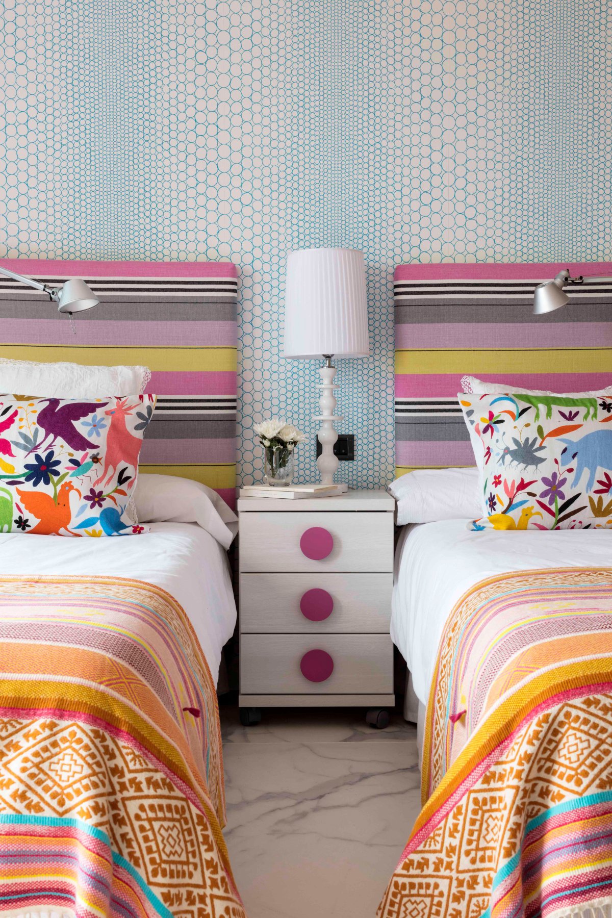 Dormitorio con colores a rayas en textil y cabecero