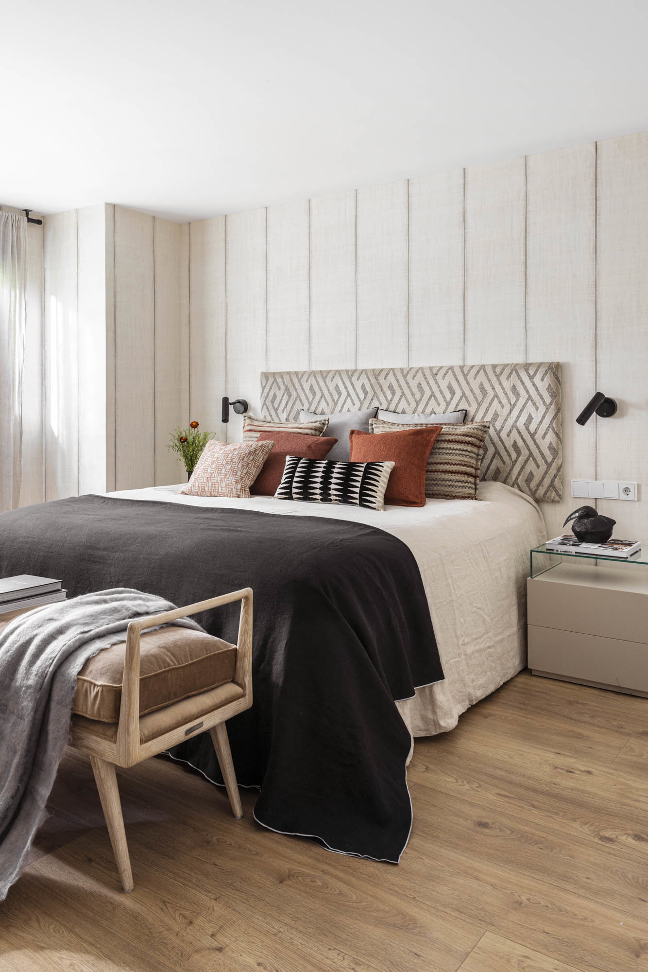 Dormitorio con cabecero de madera y con mullidos cojines