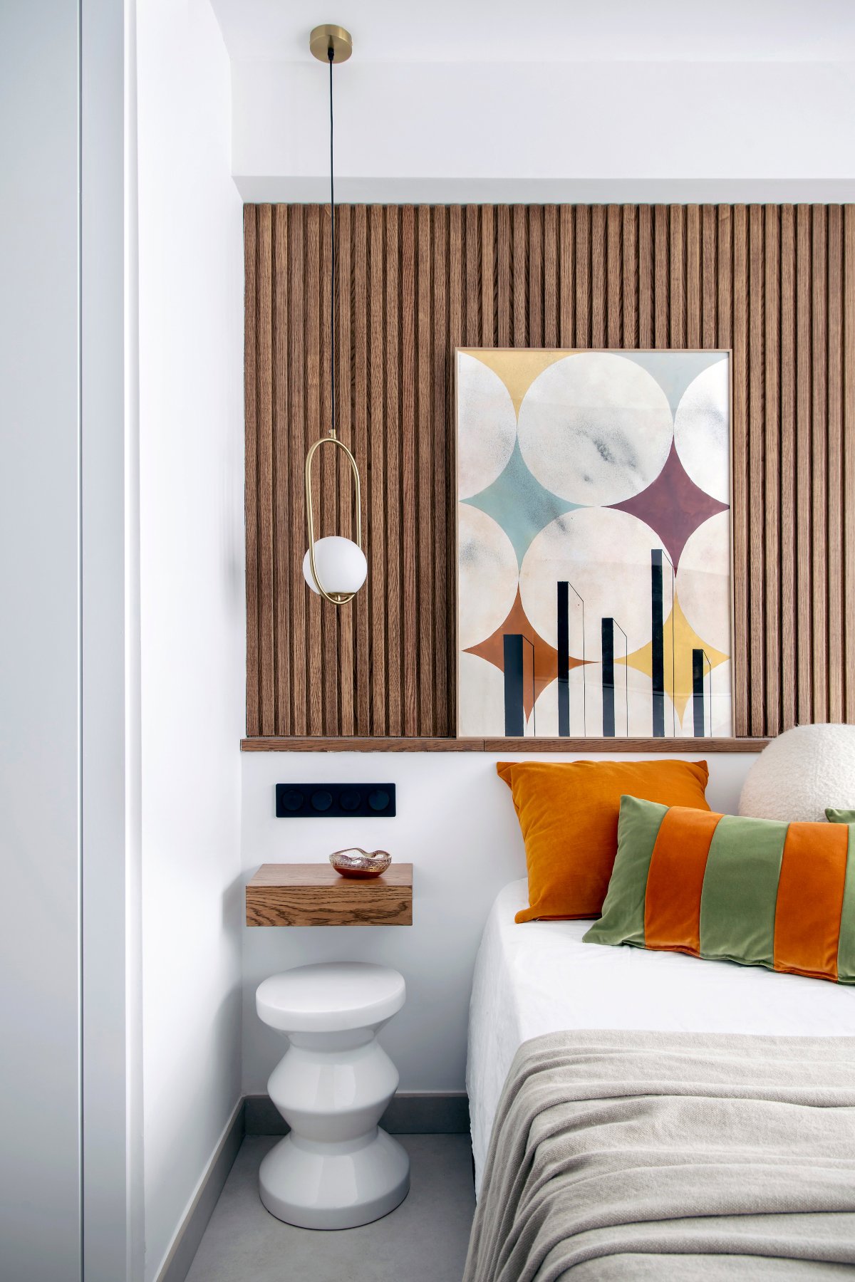 Dormitorio con cabecero de listones de madera y cuadro de rombos