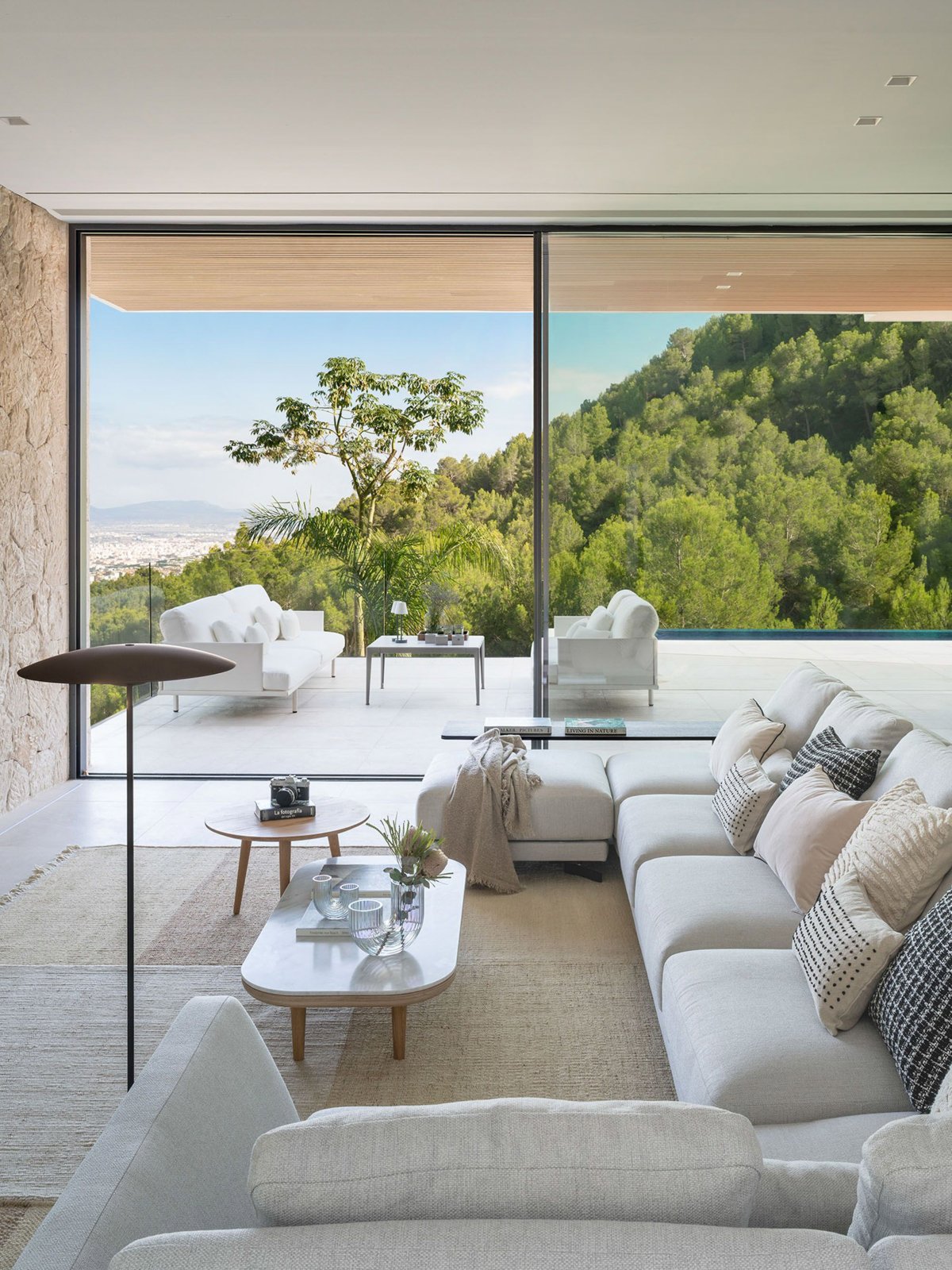 Salón minimalista en tonos grises con amplia terraza del mismo estilo