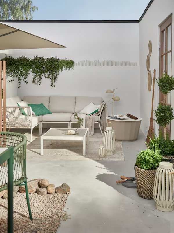 Terraza con disposición de plantas y sofá en beige