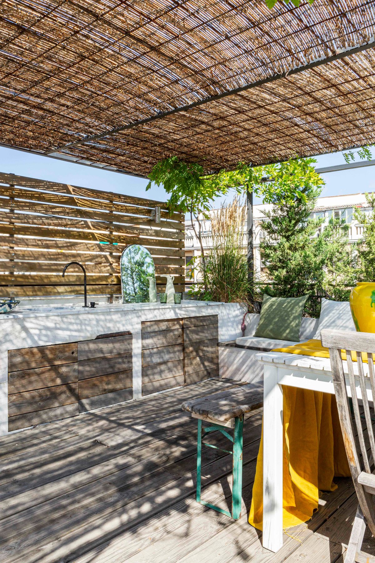 Terraza de madera con aires mediterráneos y cocina de obra