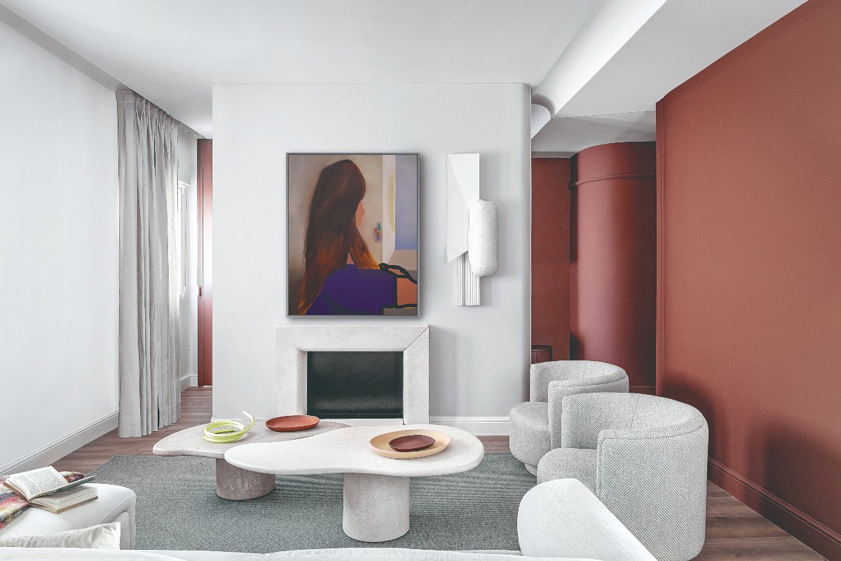 Salón blanco y color teja con chimenea integrada bajo un cuadro abstracto