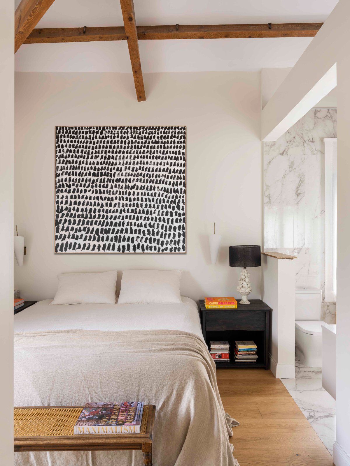 Dormitorio de vigas de madera y cuadro abstracto