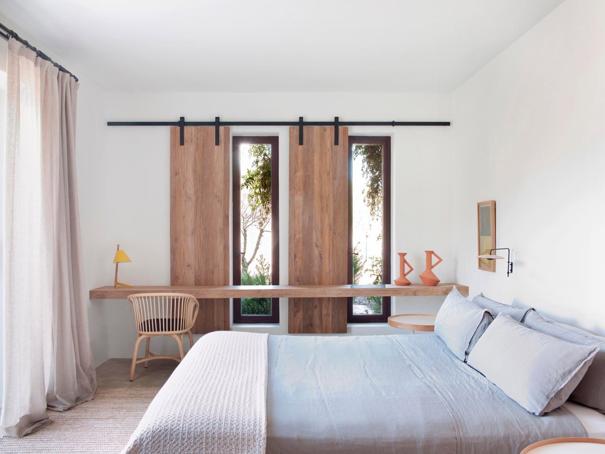 Dormitorio natural y luminoso con contraventanas de madera