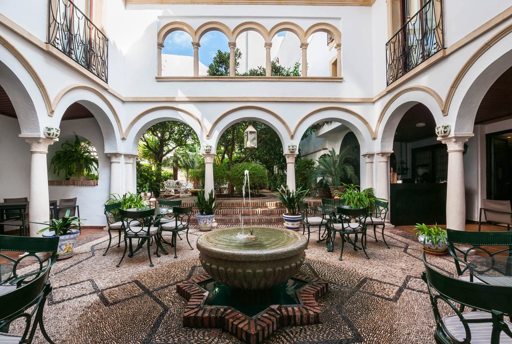 Patio de muebles de forja alrededor de una fuente