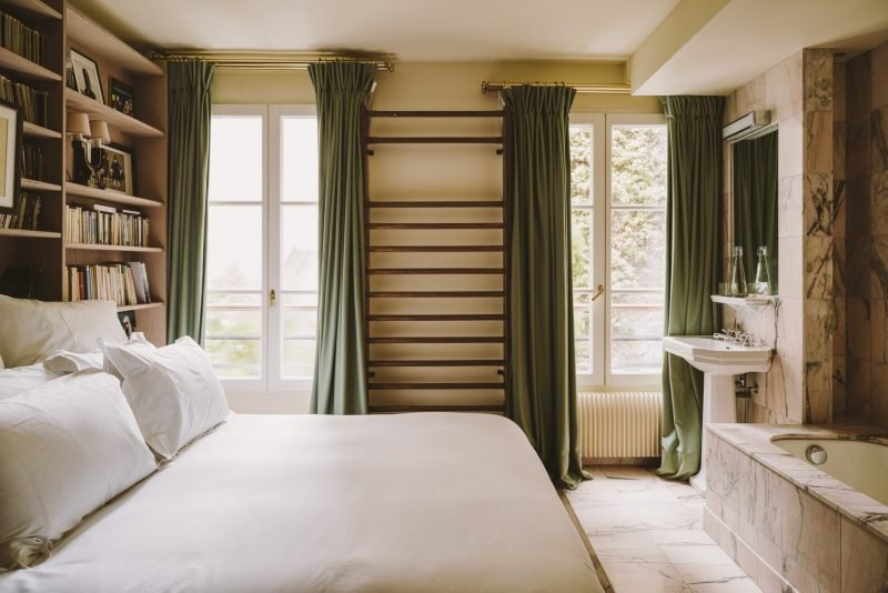 Dormitorio con largas cortinas verdes de telas gruesas