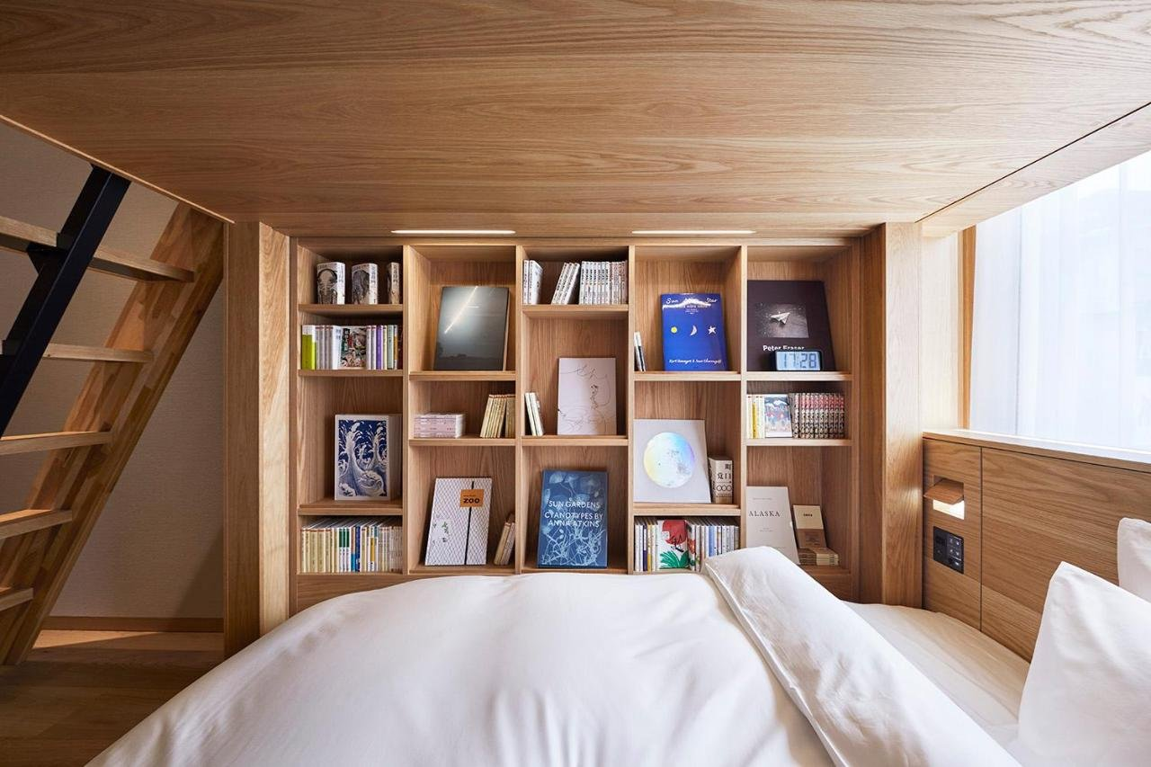 Dormitorio en madera con amplia cama en textil blanco
