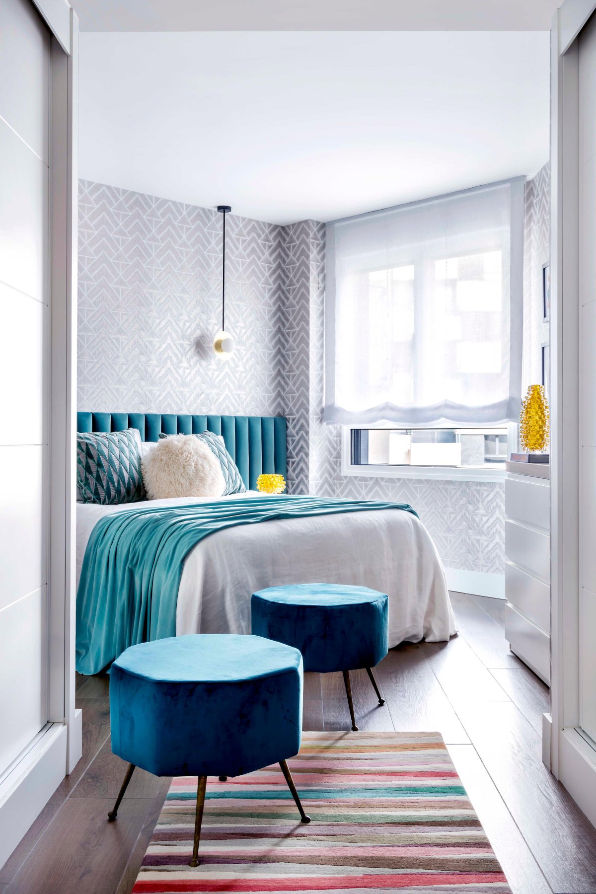 Dormitorio azul con alfombra colorida