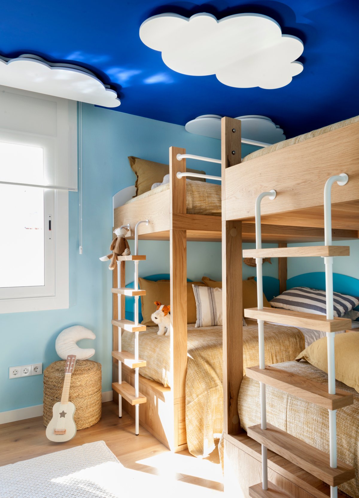 Dormitorio infantil con literas y techo azul