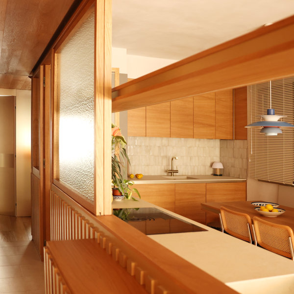 Esta cocina, blanca y de madera, hace latir el corazón de este hogar barcelonés