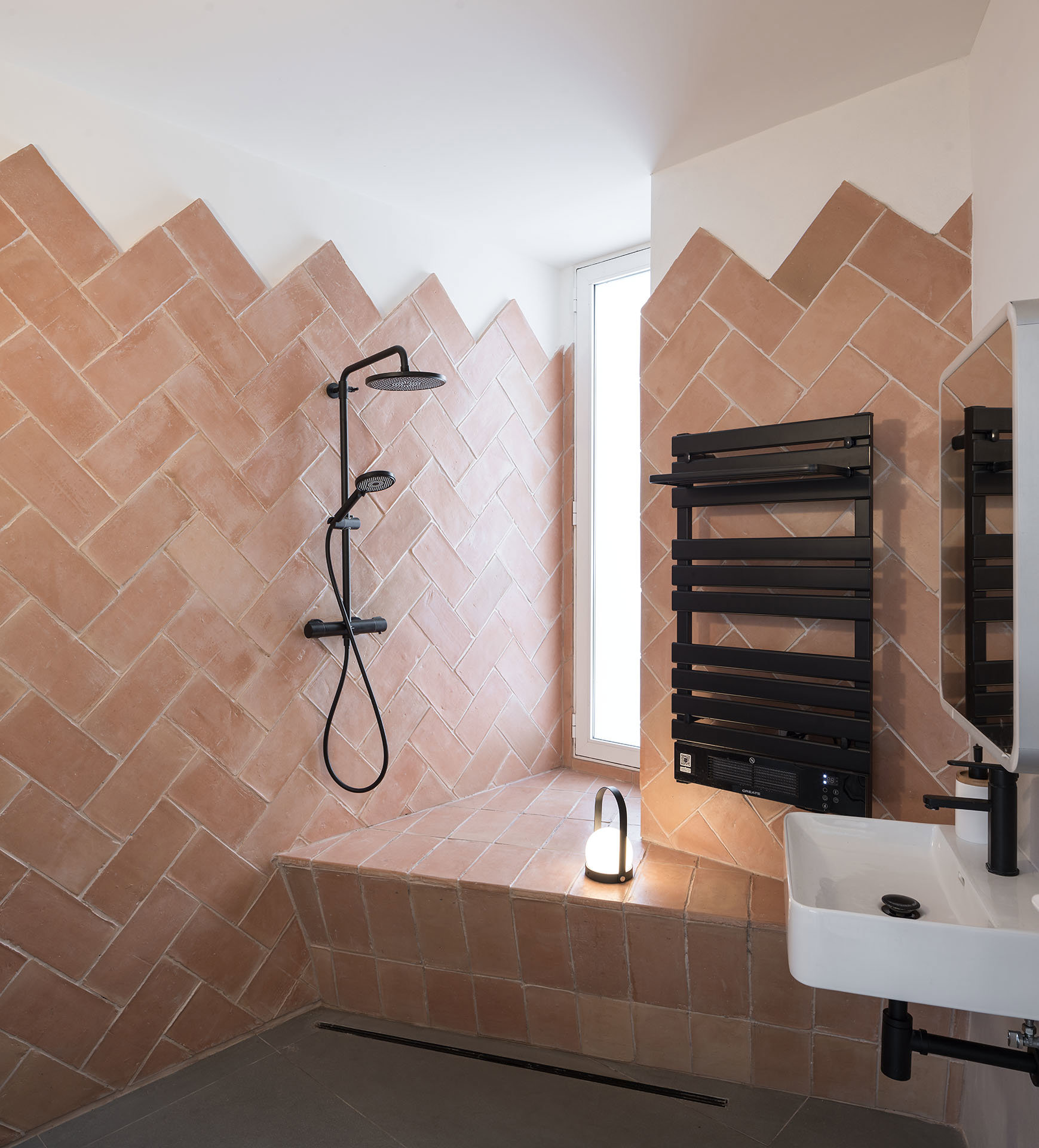 El toque mediterráneo tradicional está muy presente en todo el proyecto, como el uso del barro, combinado con el elegante negro, en este baño.