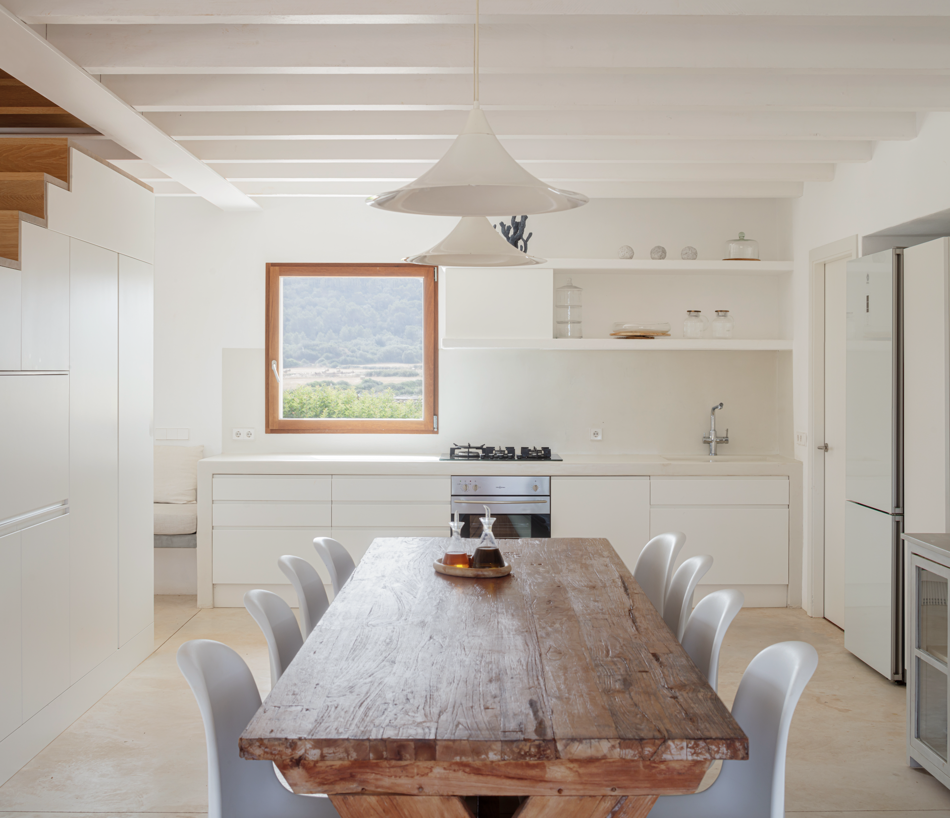 La mesa de madera original destaca por encima del color blanco predominante en la cocina.
