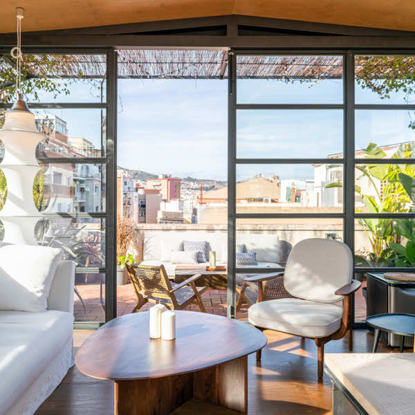 Enamórate de la terraza invernadero y de la cocina abierta de estilo industrial de este dúplex de Barcelona