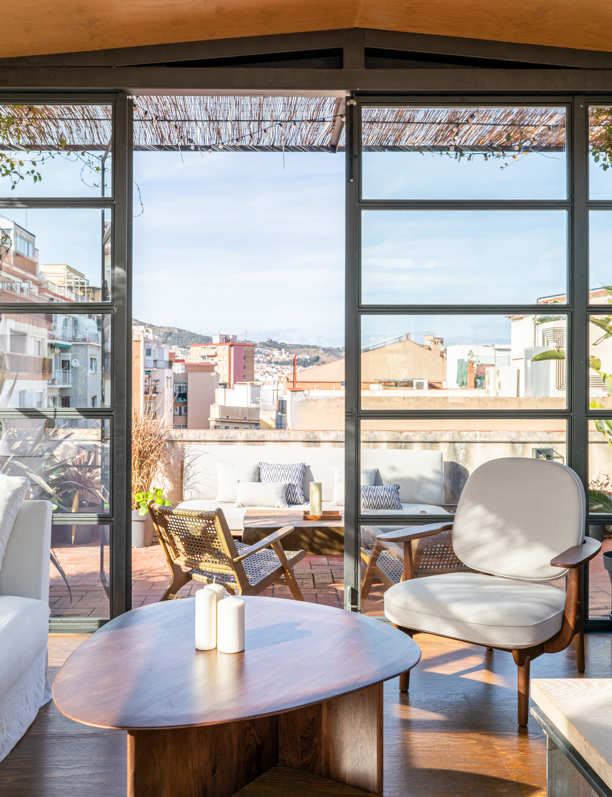 Enamórate de la terraza invernadero y de la cocina abierta de estilo industrial de este dúplex de Barcelona