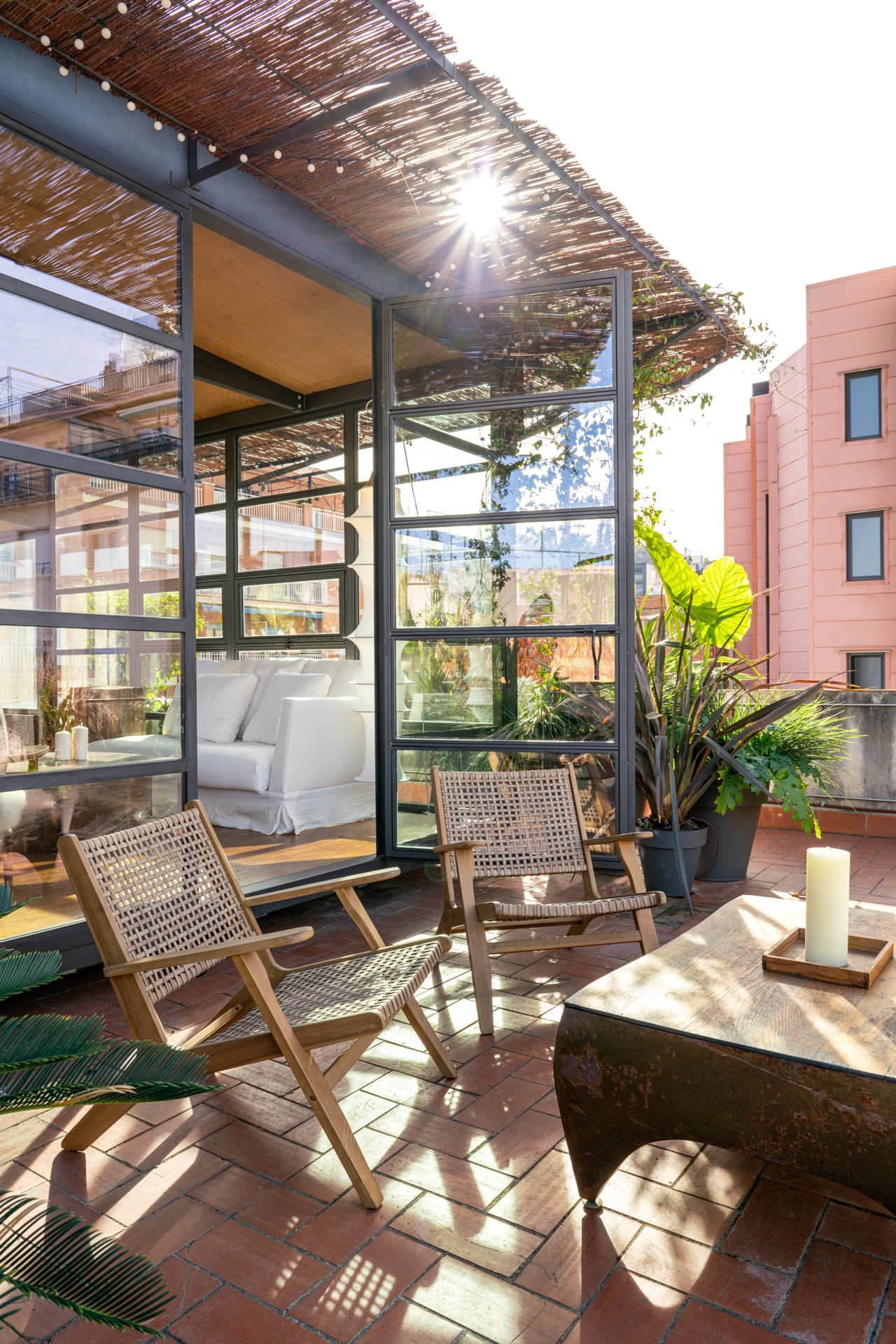 Las plantas naturales crean una atmósfera fresca en la terraza que recuerda mucho a un invernadero.