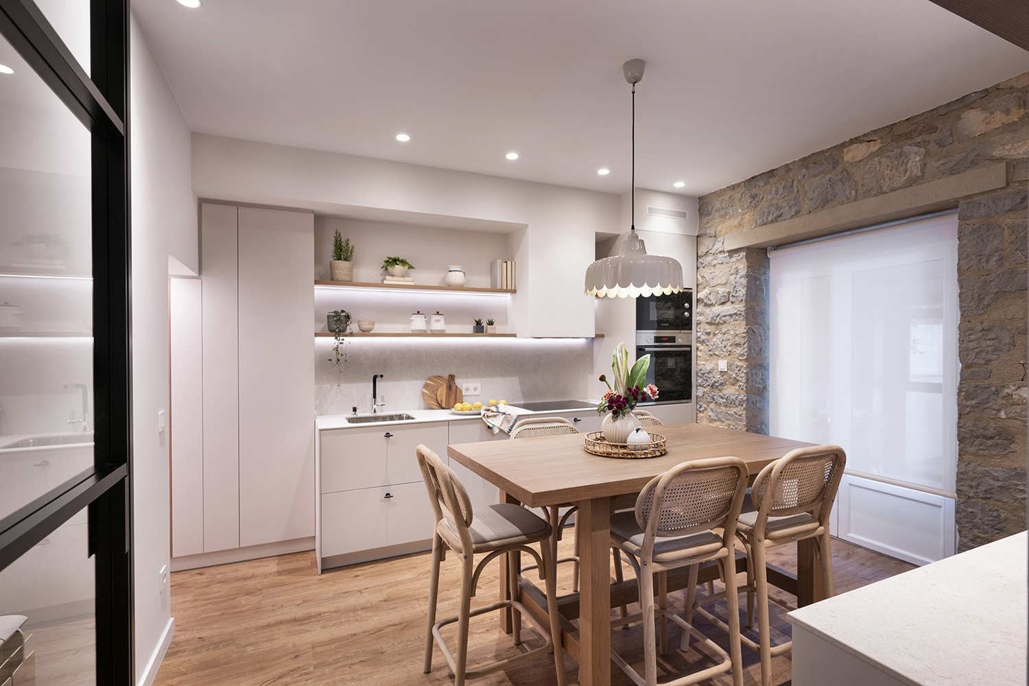 cocina con mesa centro y pared piedra