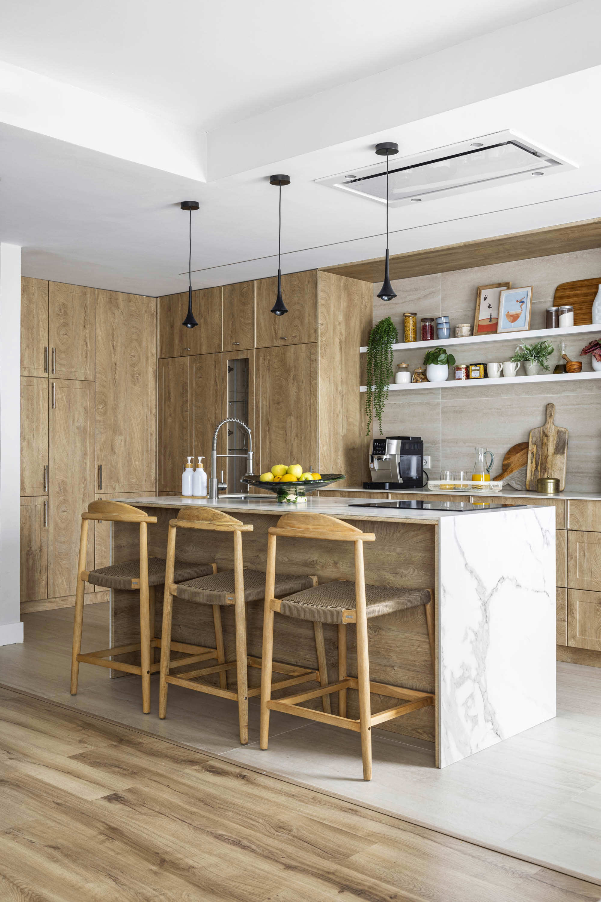 cocina con muebles madera con isla, barra y taburetes