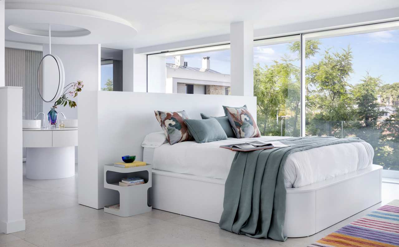 dormitorio blanco con ventanales y vistas