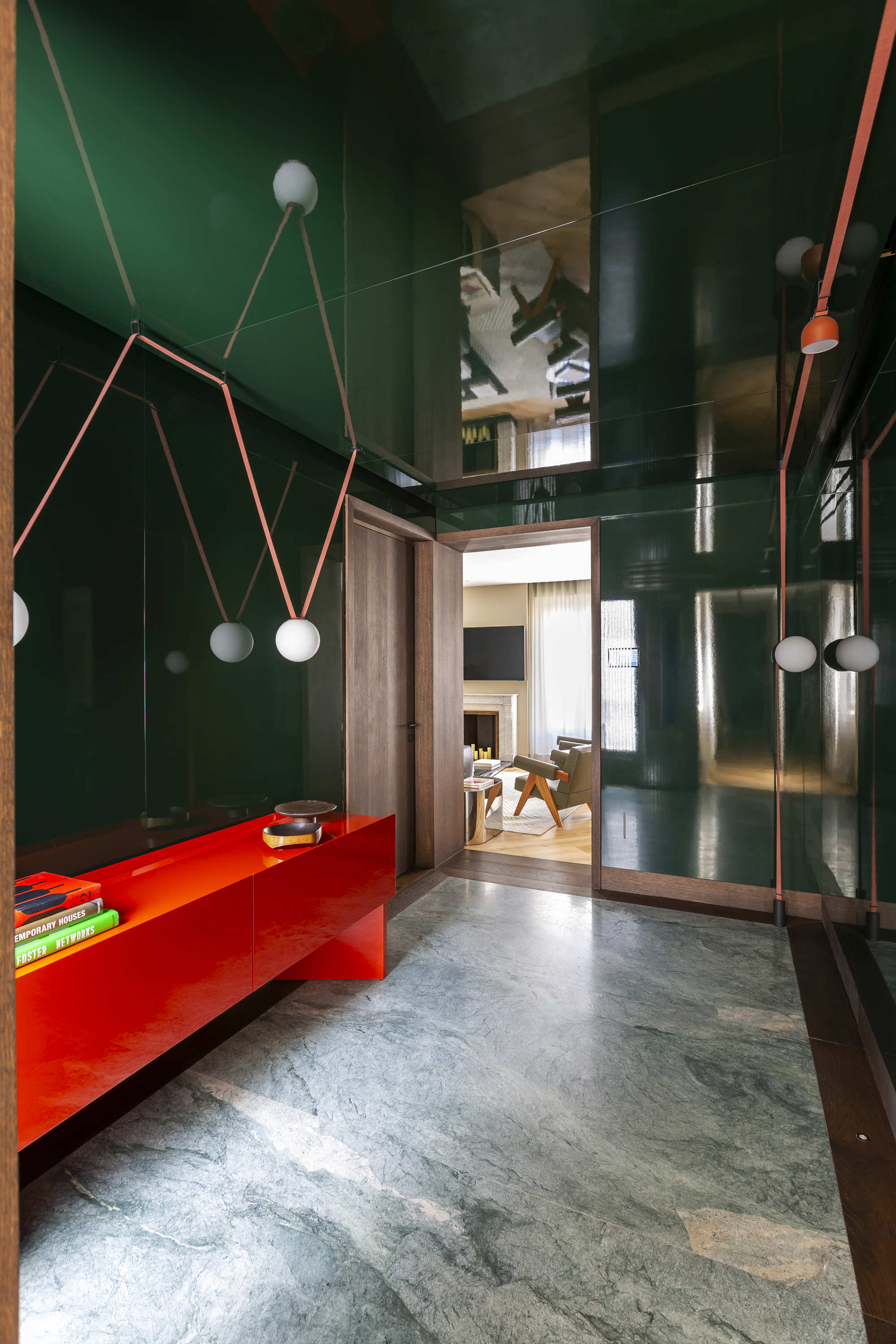 hall oscuro en verde y mueble rojo