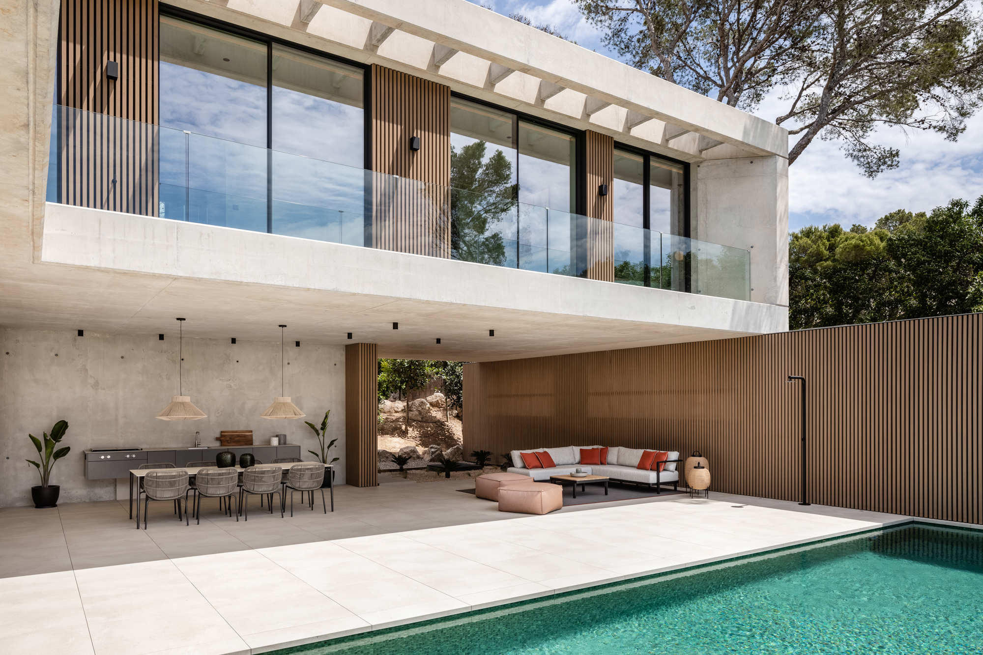 Casa en hormigón con piscina y pared madera