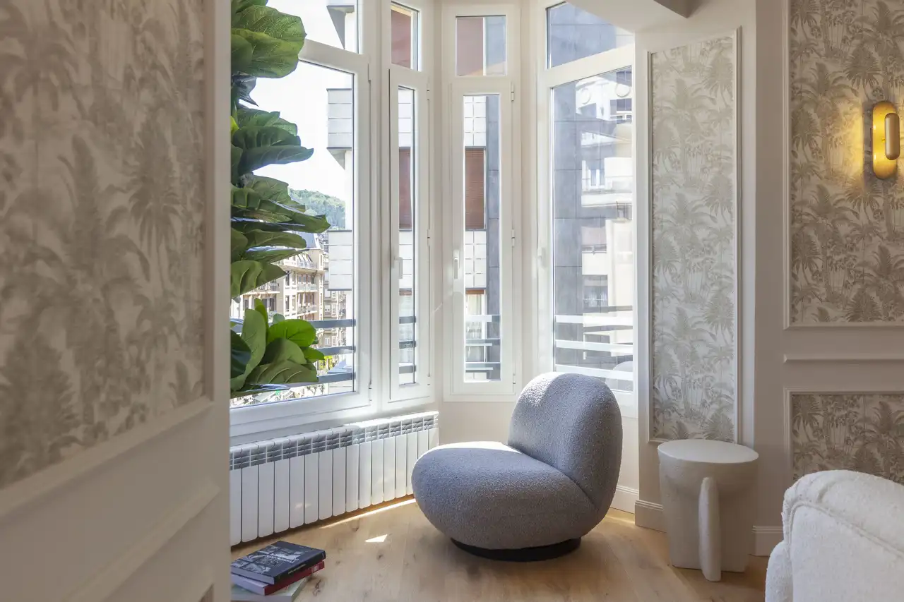 El mirador en la esquina del edificio se ha aprovechado para crear un sencillo rincón de lectura, con un puff de Unika Collection.