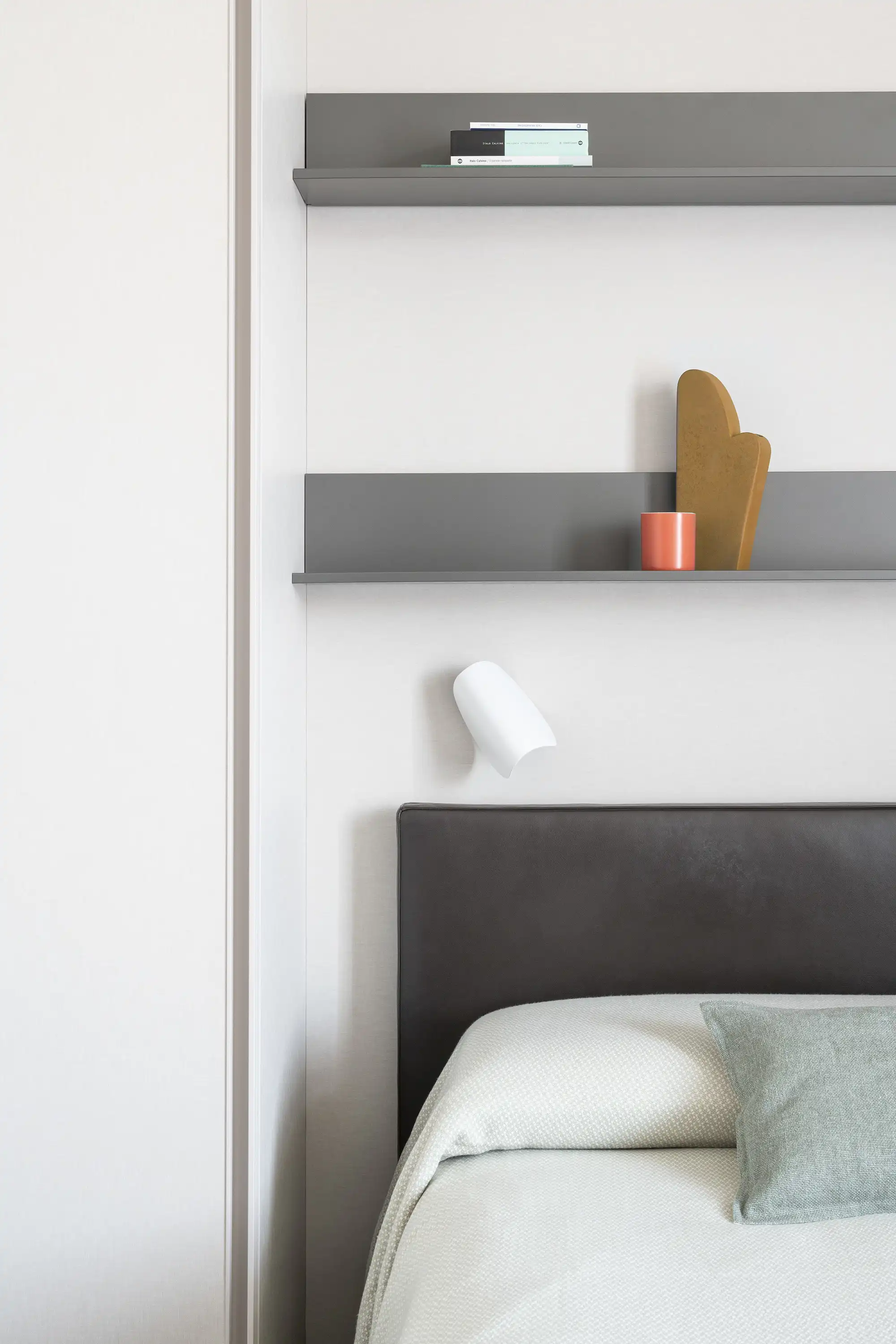 En el detalle del dormitorio destaca la selección de tonos neutros, en armonía con la paleta de colores adoptada por el resto de la vivienda. Aplique orientable, de Fontana Arte.